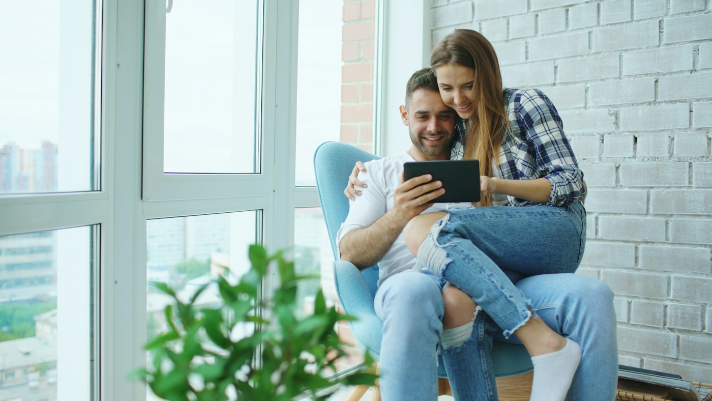 Un couple consulte une tablette chez lui — photo d’illustration